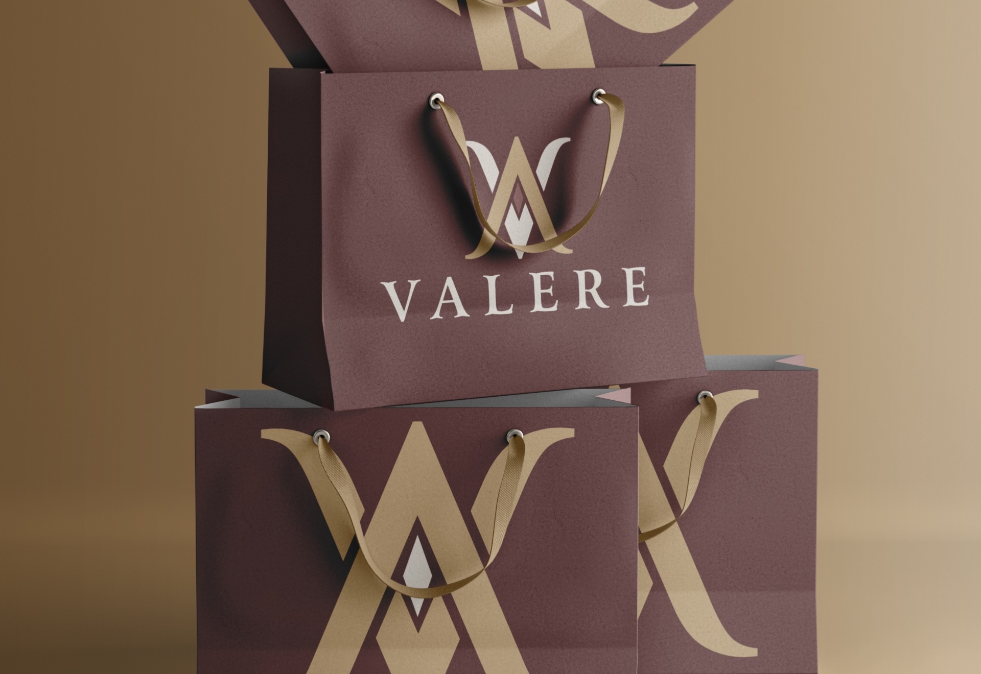 Stacked Valere paper shopping bags in various sizes and logo variations – fashion branding and visual identity design by Wotbbi.